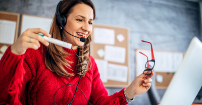 Woman with glasses and headset at laptop